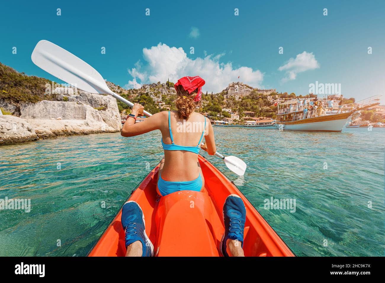 Happy girl fait de l'aviron sur un double kayak de mer avec son ami près de l'île de Kekova avec vue sur le château de Simena et le village de Kaleucagiz en Turquie.Enregistrement extérieur Banque D'Images