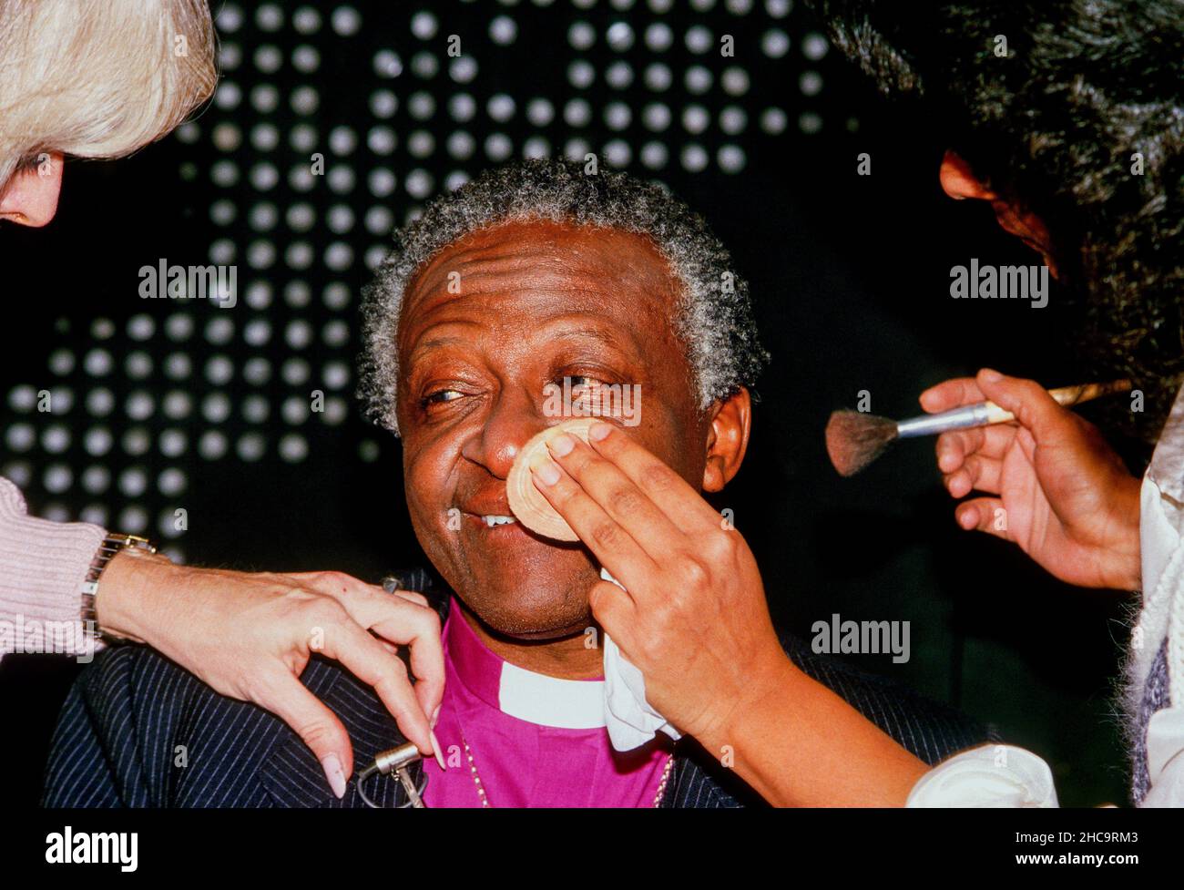L'évêque Desmond Tutu reçoit du maquillage appliqué sur son visage avant sa toute première apparition sur le CNN Cable News show 'Larry King Live' Washington DC., juillet, 1985.Crédit : Mark Reinstein/MediaPunch Banque D'Images