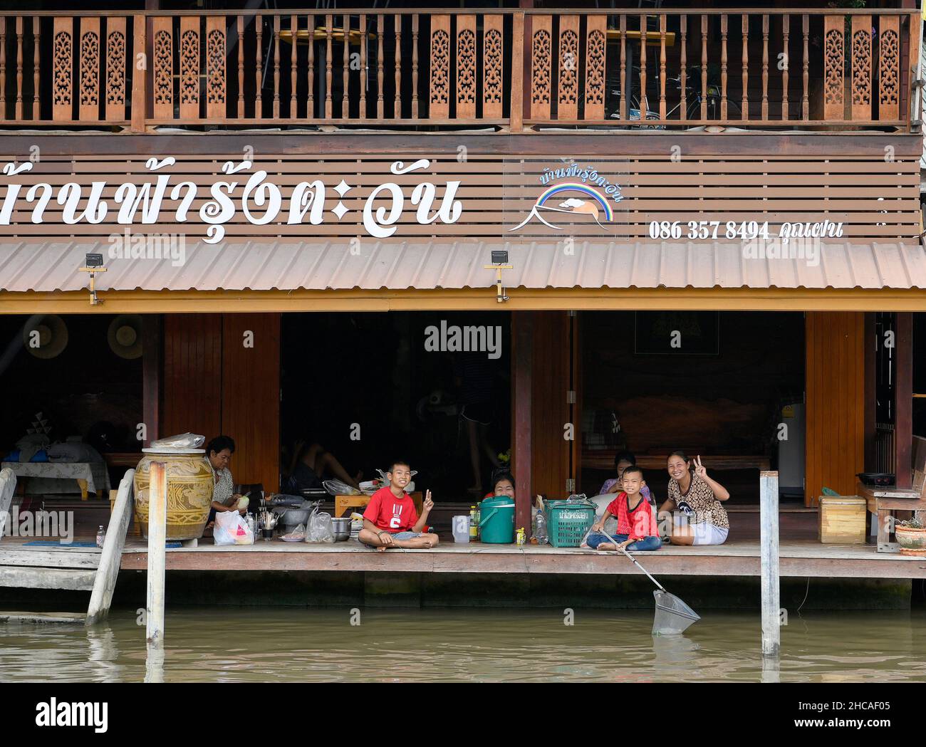 Amphawa, Thaïlande.26th décembre 2021.Une famille pose pour une photo au marché flottant d'Amphawa, environ 90km au sud-ouest de Bangkok, dans la province de Samut Songkhram, ouvert sur Fridayís, Saturday et Sundayís.Les bateaux motorisés à longue queue offrent aux touristes des promenades en bateau à travers une série de klongs (canaux), et une foule de voies d'eau avec des boutiques vendant une variété de bonbons thaïlandais, poissons séchés et herbes, de nombreux restaurants offrent également des plats de soupe de nouilles et des jus de fruits exotiques.Les communautés du marché flottant sont considérées comme un patrimoine culturel thaïlandais précieux.Crédit : SOPA Images Limited/Alamy Live News Banque D'Images
