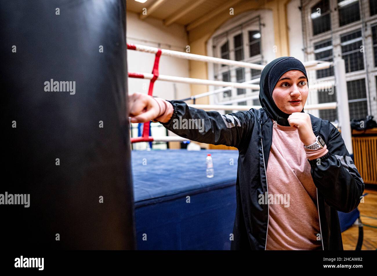 16 décembre 2021, Berlin: L'entraîneur de boxe Doha Taha Beydoun se tient dans la pratique de boxe de gym.Elle n'a que 20 ans.Marié.Quatre mois de grossesse.Musulman et un entraîneur de boxe.Ses parents ont émigré du Liban vers l'Allemagne quand elle était bébé.Doha Taha Beydoun semble 'trange' à certains, dit-elle, parce que sa nationalité, sa religion et son sport ne correspondent pas.D'autres la voient comme un modèle, comme elle le dit elle-même."Je lutte contre tous les préjugés", se donne la jeune femme avec confiance.(À dpa 'Mussim, femme, entraîneur de boxe - 'Je lutte contre tous les préjugés') photo: Fabian Sommer/dpa Banque D'Images