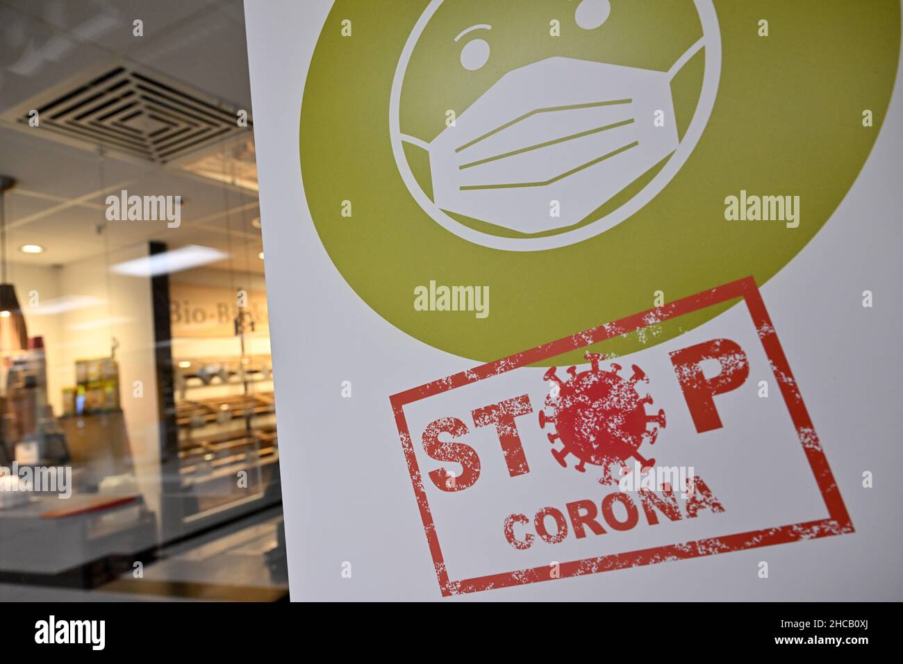 Munich, Allemagne.27th décembre 2021.Une affiche indiquant « Stop Corona » est suspendue dans la fenêtre d'un magasin.Credit: Peter Kneffel/dpa/Alay Live News Banque D'Images