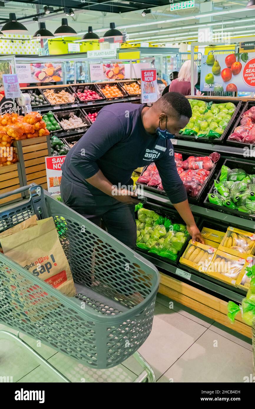 Cape Town, Afrique du Sud - 9 septembre 2021 : un membre du personnel cueille des produits à partir de l'étagère pour un service de livraison express à domicile Banque D'Images