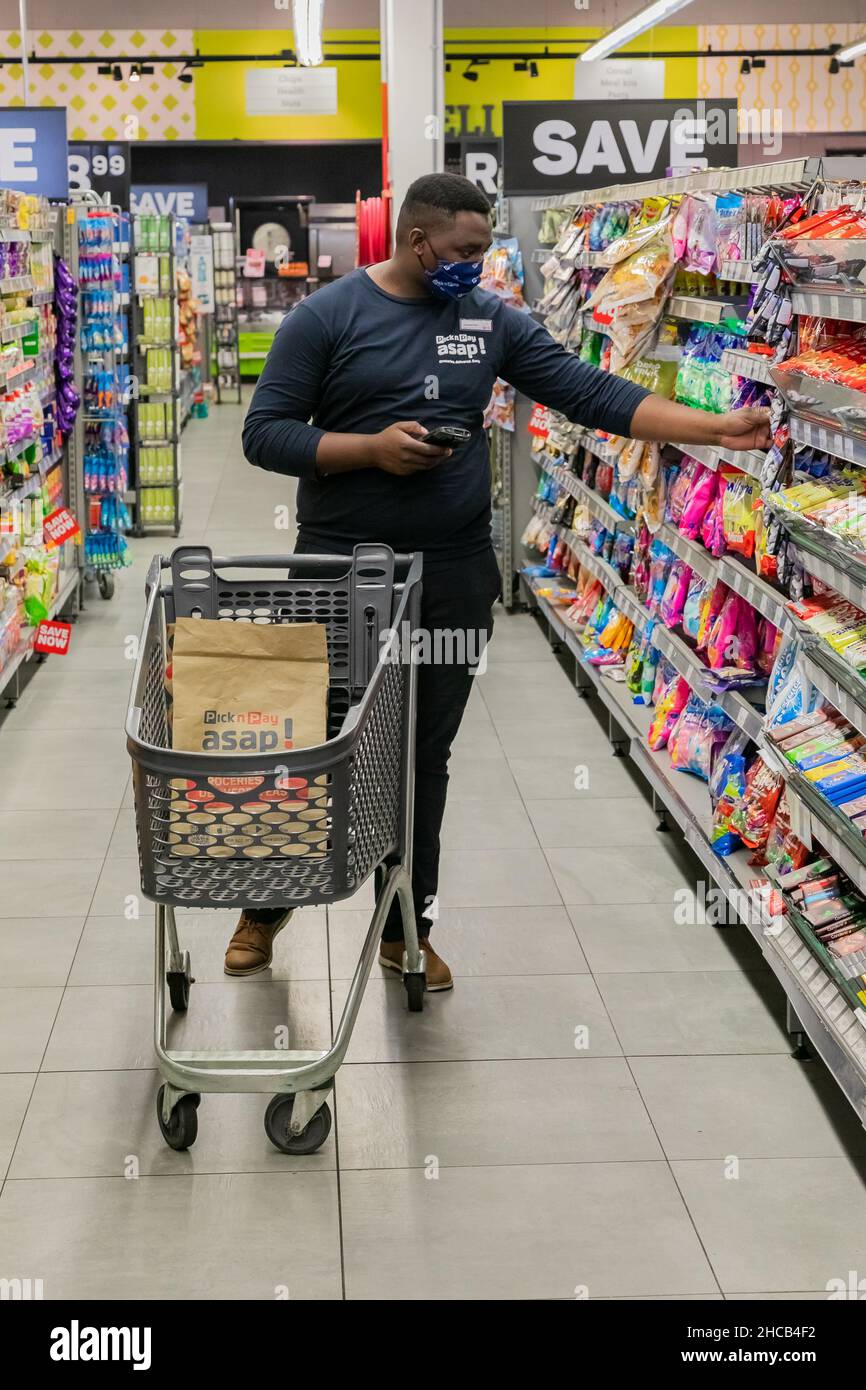 Cape Town, Afrique du Sud - 9 septembre 2021 : un membre du personnel cueille des produits à partir de l'étagère pour un service de livraison express à domicile Banque D'Images