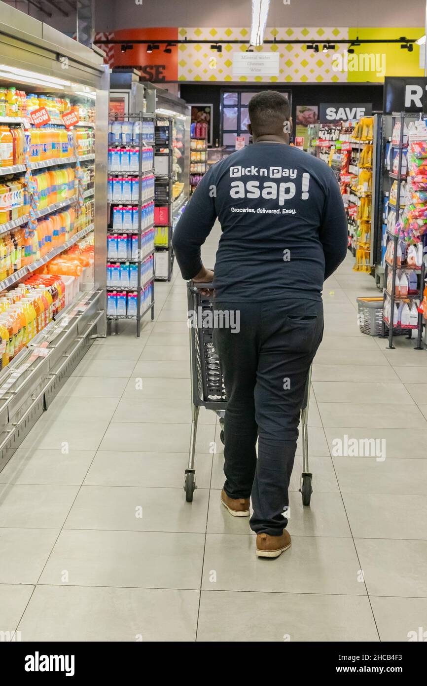 Cape Town, Afrique du Sud - 9 septembre 2021 : un membre du personnel cueille des produits à partir de l'étagère pour un service de livraison express à domicile Banque D'Images