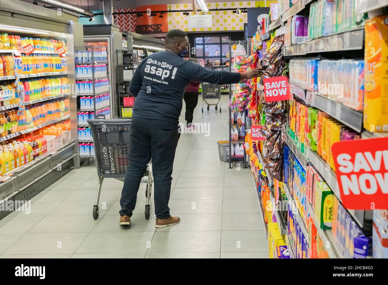 Cape Town, Afrique du Sud - 9 septembre 2021 : un membre du personnel cueille des produits à partir de l'étagère pour un service de livraison express à domicile Banque D'Images