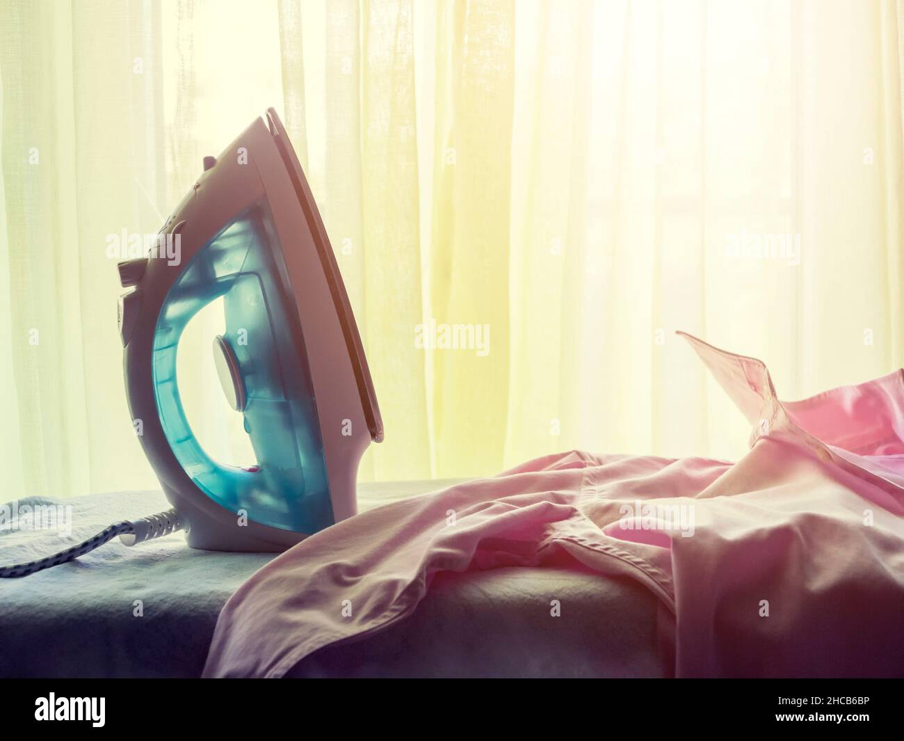 Chemise rose et fer et planche à repasser Banque D'Images