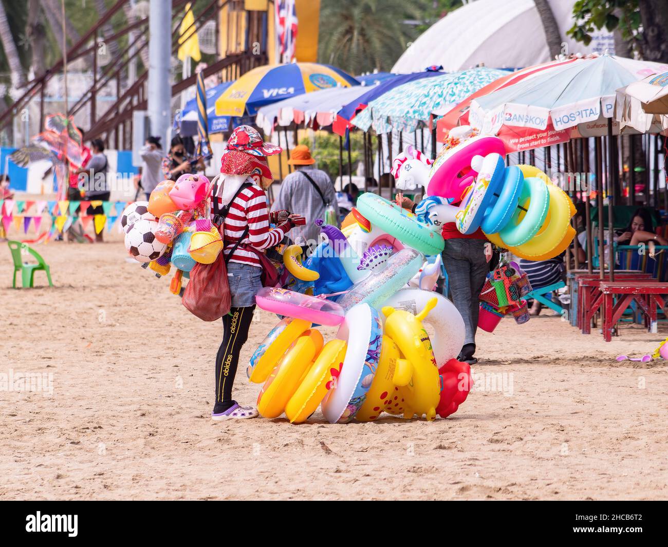 Vendeurs vendant des jouets gonflables de natation à la plage à Pattaya, Thaïlande. Banque D'Images