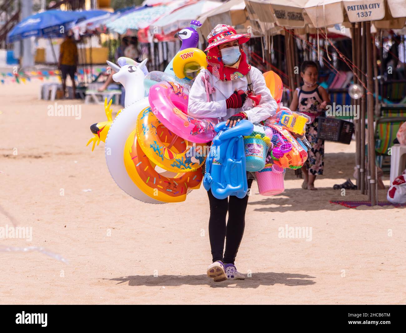 Vendeur vendant des jouets gonflables de natation à la plage à Pattaya, Thaïlande. Banque D'Images