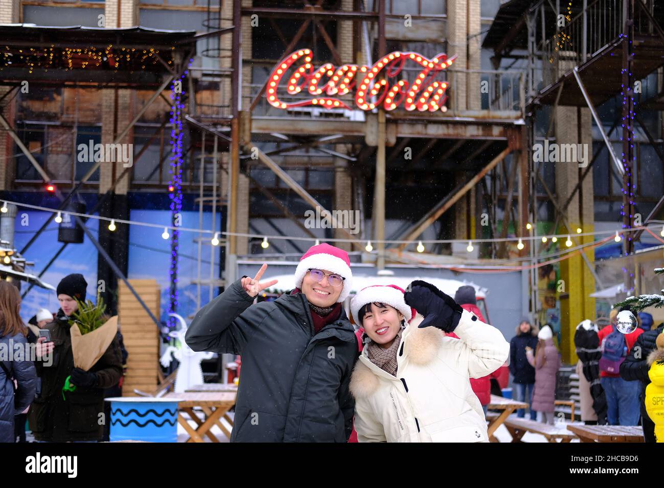 Minsk, Bélarus, 25 décembre 2021 : salon du nouvel an.Portrait d'un homme et d'une femme chinois portant des chapeaux du père noël Banque D'Images