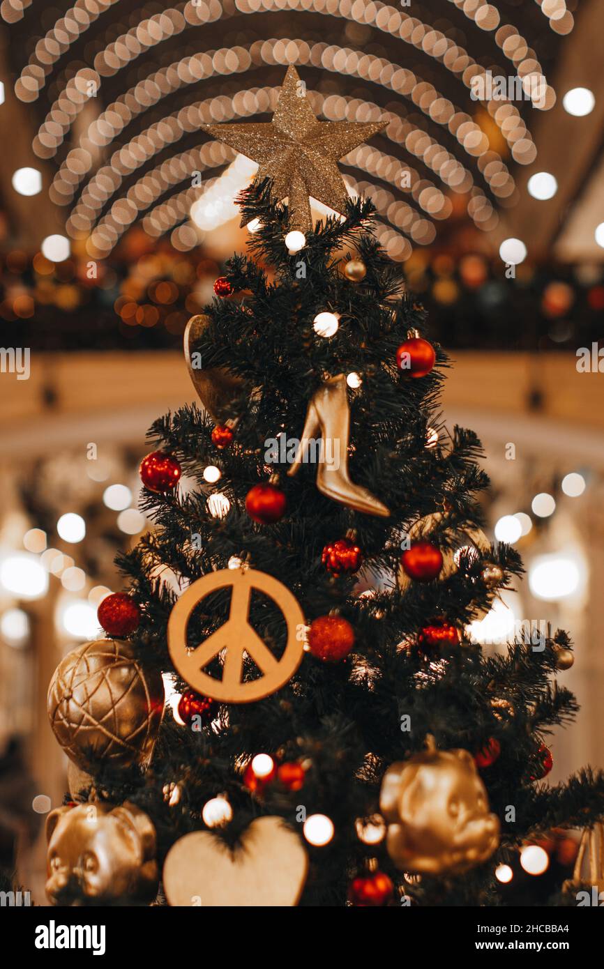 Décoration de Noël avec figurine hippie Icon et chaussures à talons hauts pour femmes accrochées à un arbre de Noël.Décor créatif Banque D'Images