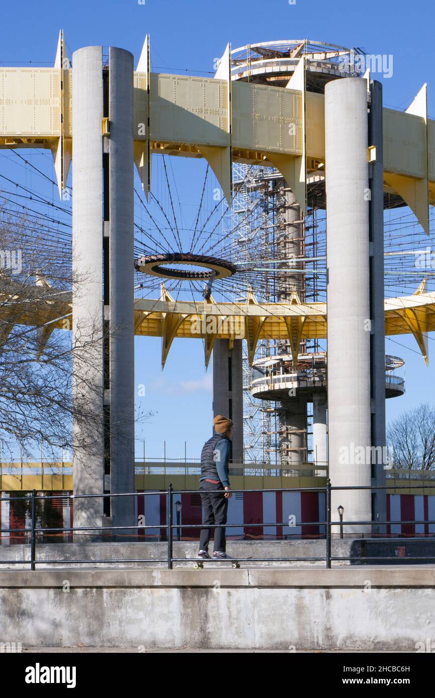 Avec le pavillon de l'État de New York en arrière-plan, un skateboarder se promènait au parc de Skate Maloof dans le parc de Flushing Meadows Corona dans le Queens. Banque D'Images