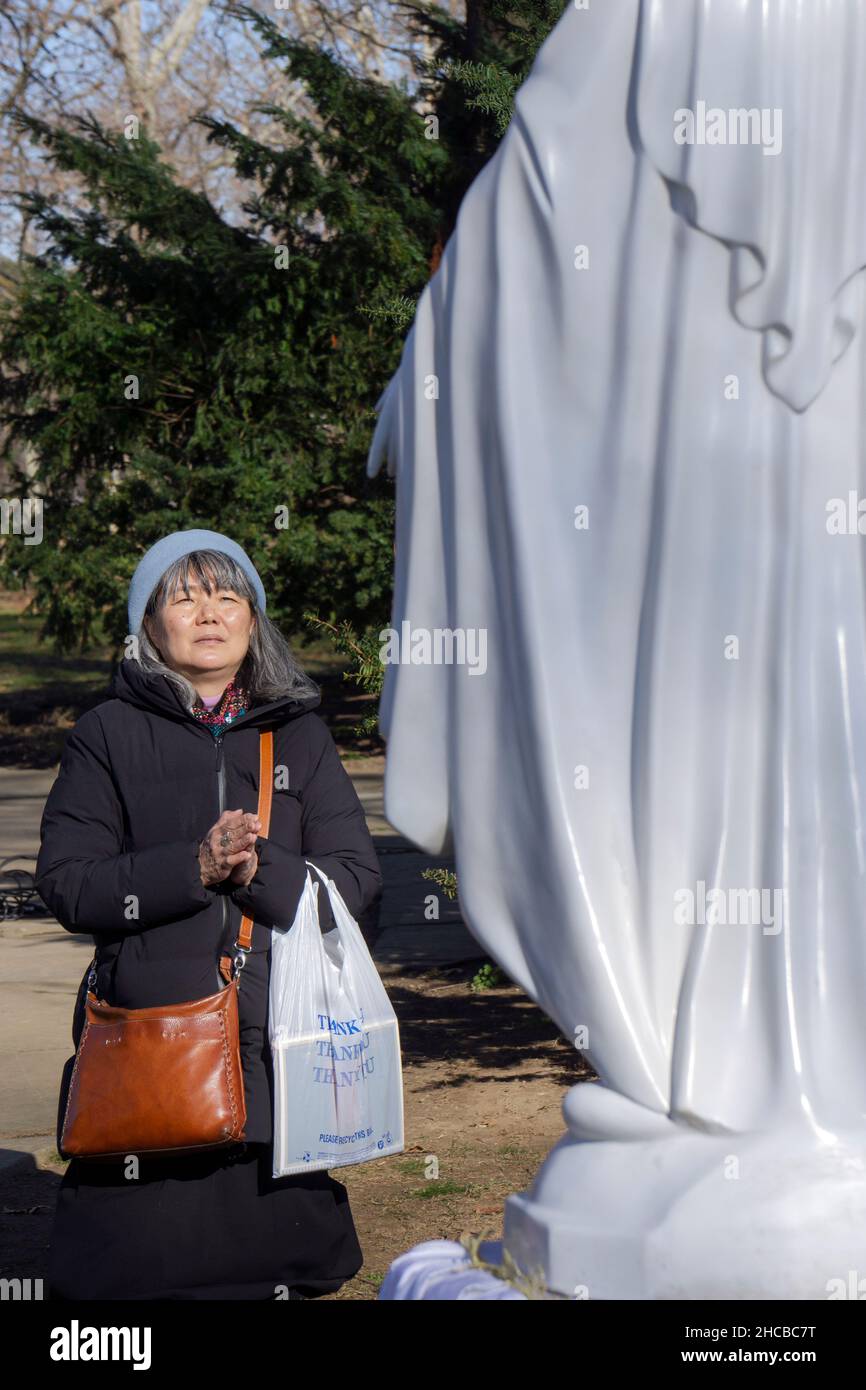 Après un service de prière dans un parc, dévoter catholique romain prie une statue de la Vierge Marie.Sur le site des apparitions de Veronica Lueken à New York. Banque D'Images