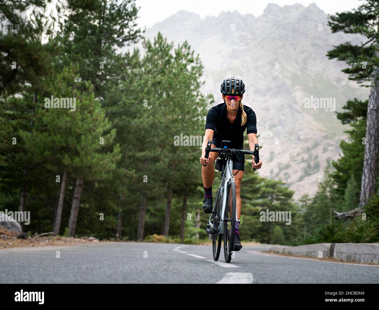 Sportswoman portant un casque à vélo sur la route Banque D'Images