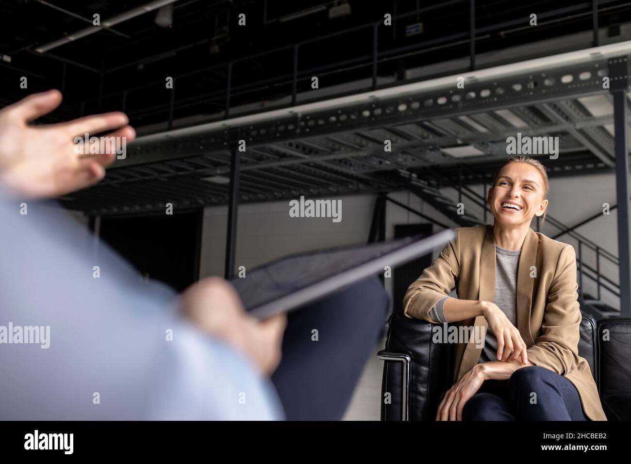 Bonne femme d'affaires discutant avec un homme d'affaires qui se fait un plaisir dans le hall Banque D'Images