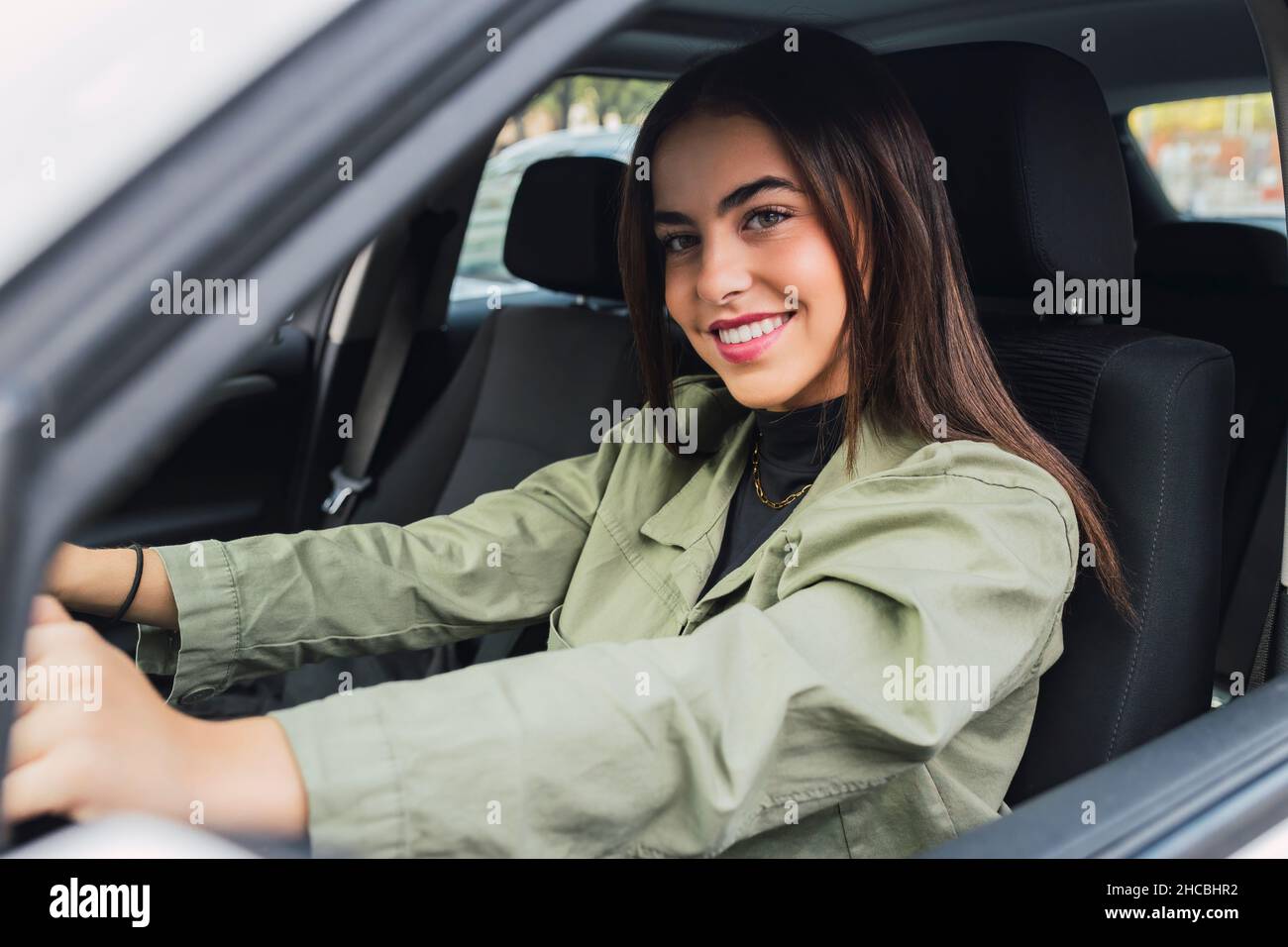 Jeune femme souriante conduisant la voiture Banque D'Images