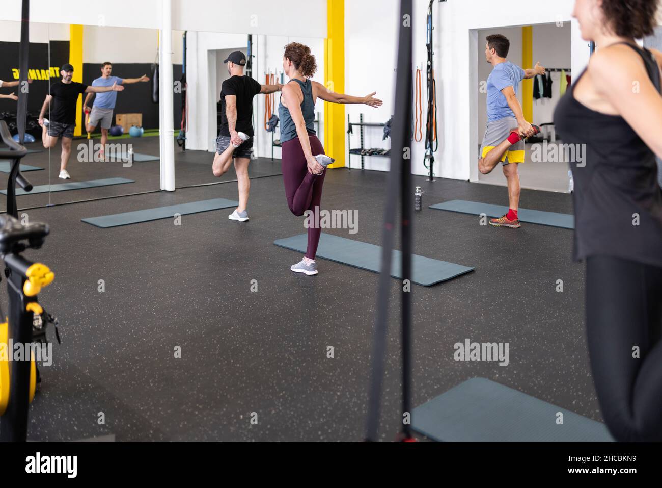 Les athlètes qui font de l'exercice d'étirement dans la salle de gym Banque D'Images