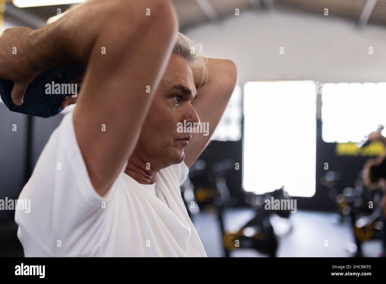 Sportif avec exercice de poids dans la salle de gym Banque D'Images