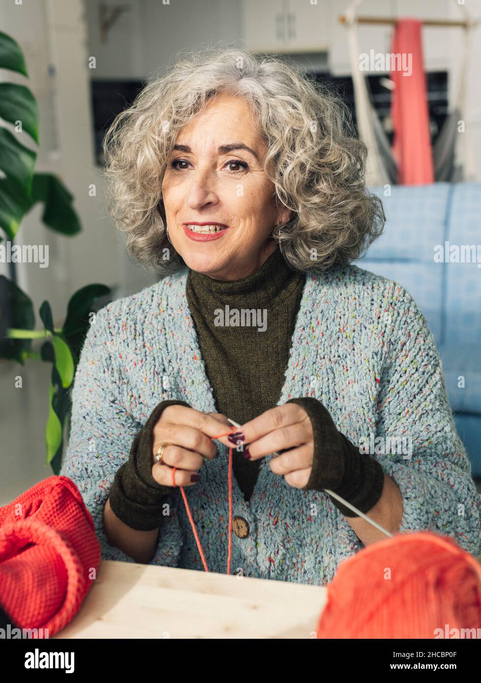 Femme sénior enregistrant pendant que je cousue et tricoter à la maison Banque D'Images