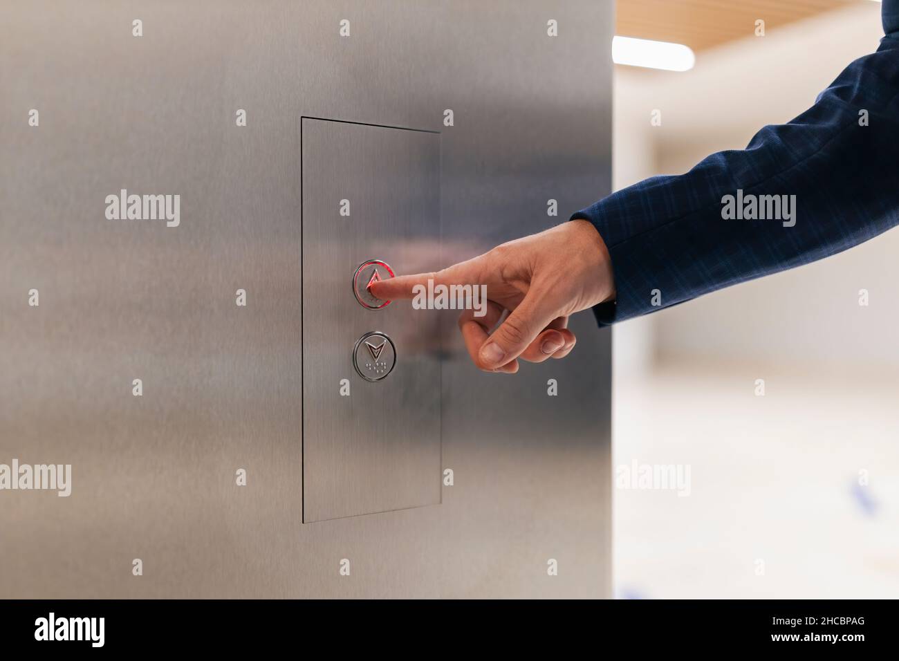 Homme d'affaires utilisant le bouton-poussoir de l'ascenseur Banque D'Images