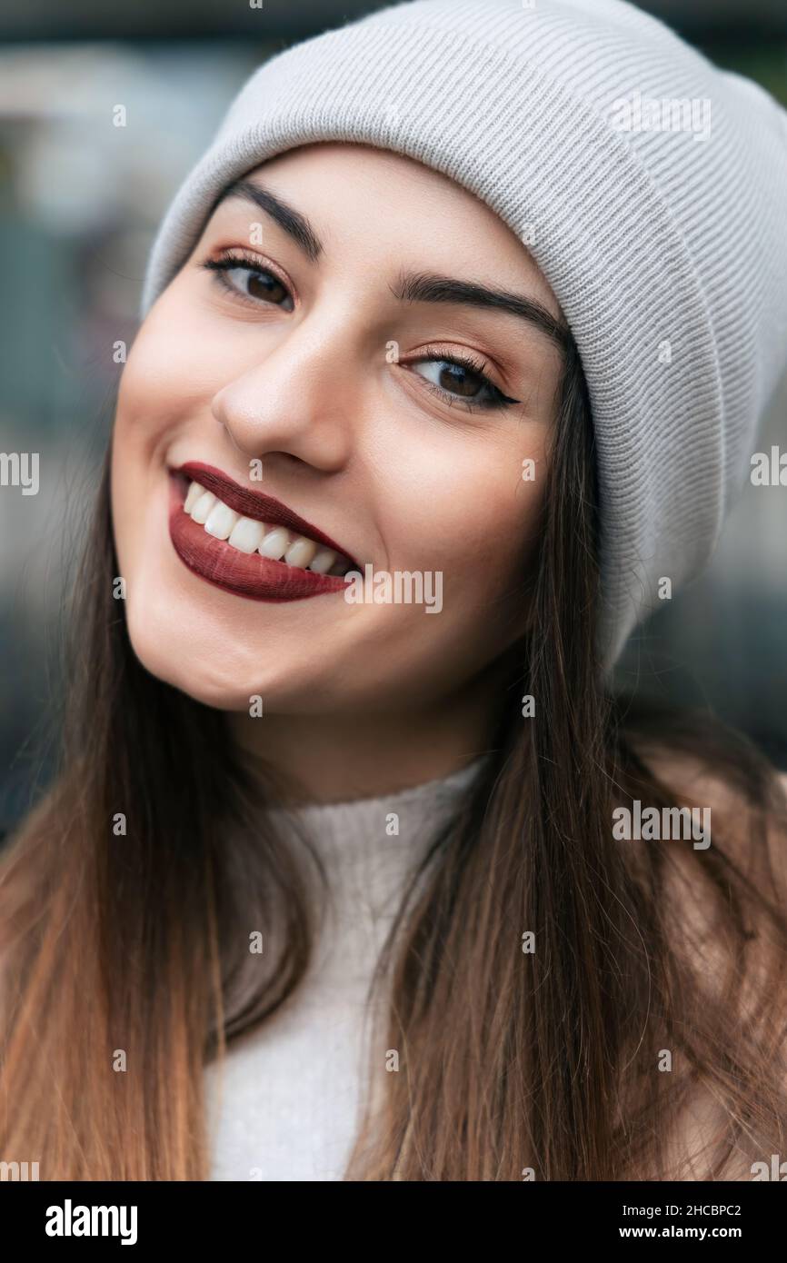 Belle femme souriante portant un chapeau en tricot Banque D'Images