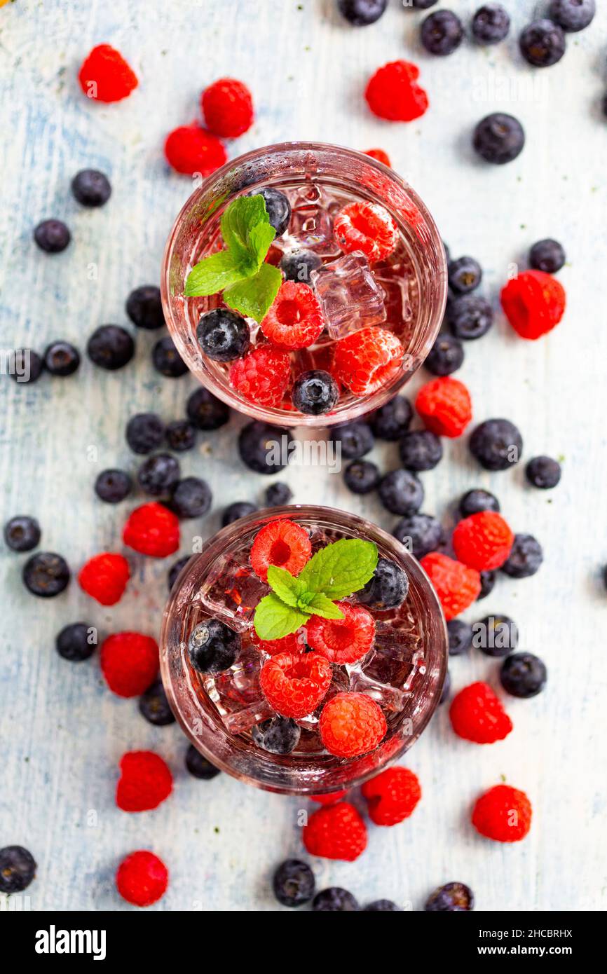 Deux verres de gin tonique à la menthe, des glaçons et des baies crues Banque D'Images