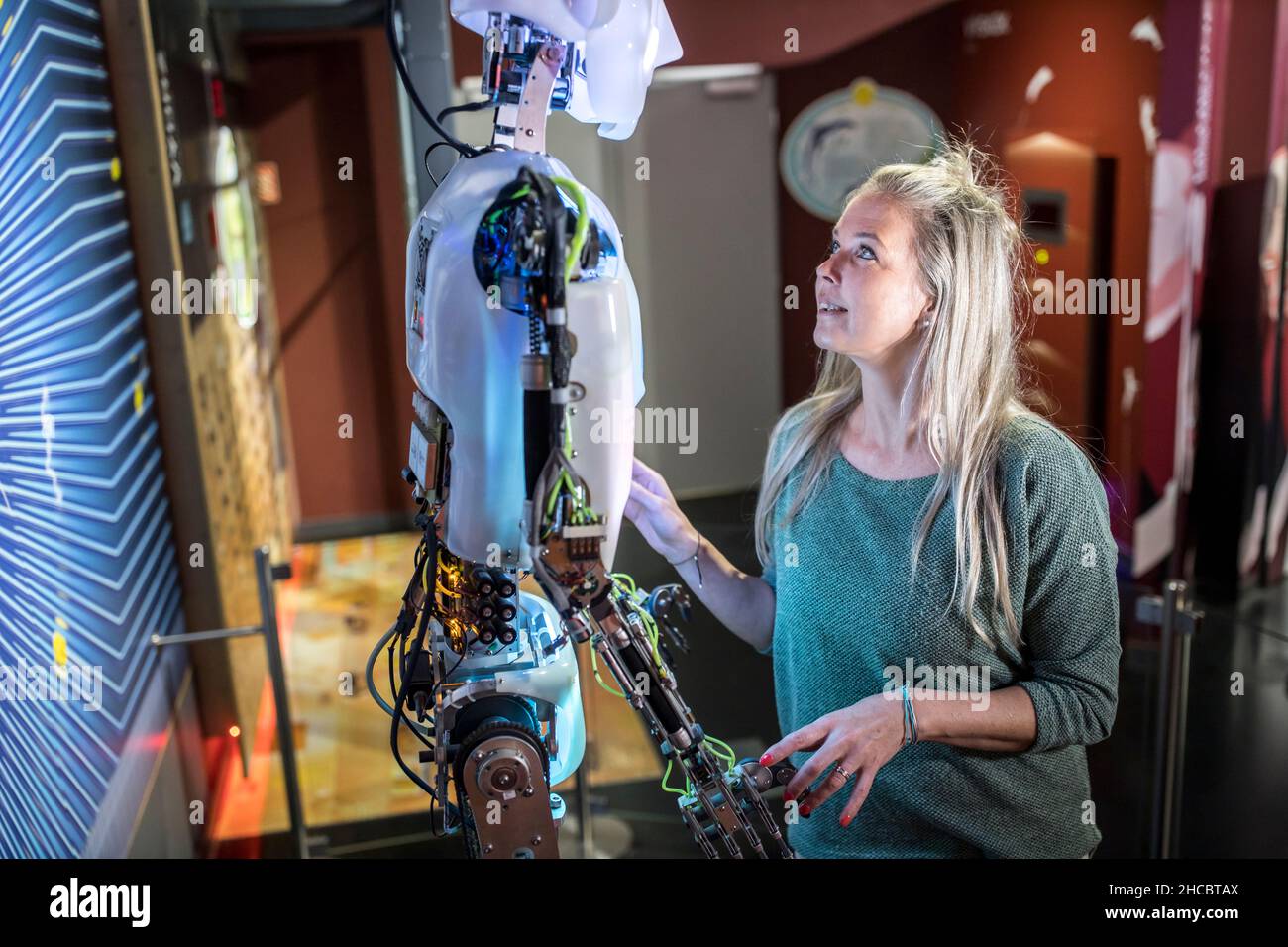 Technicien parlant et regardant le robot humain en atelier Banque D'Images