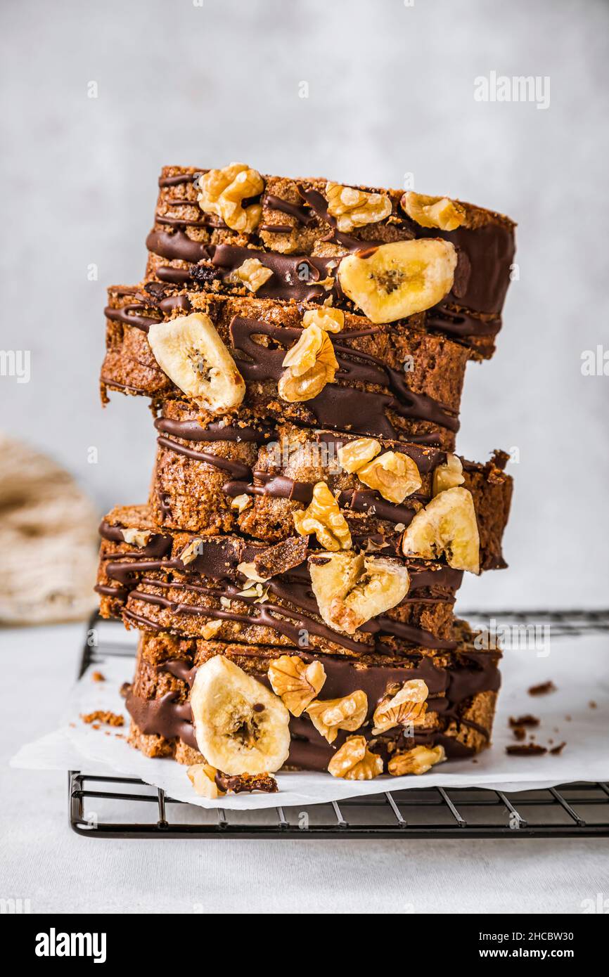 Gâteau de banane en tranches avec noix et sauce au chocolat sur la planche à découper Banque D'Images