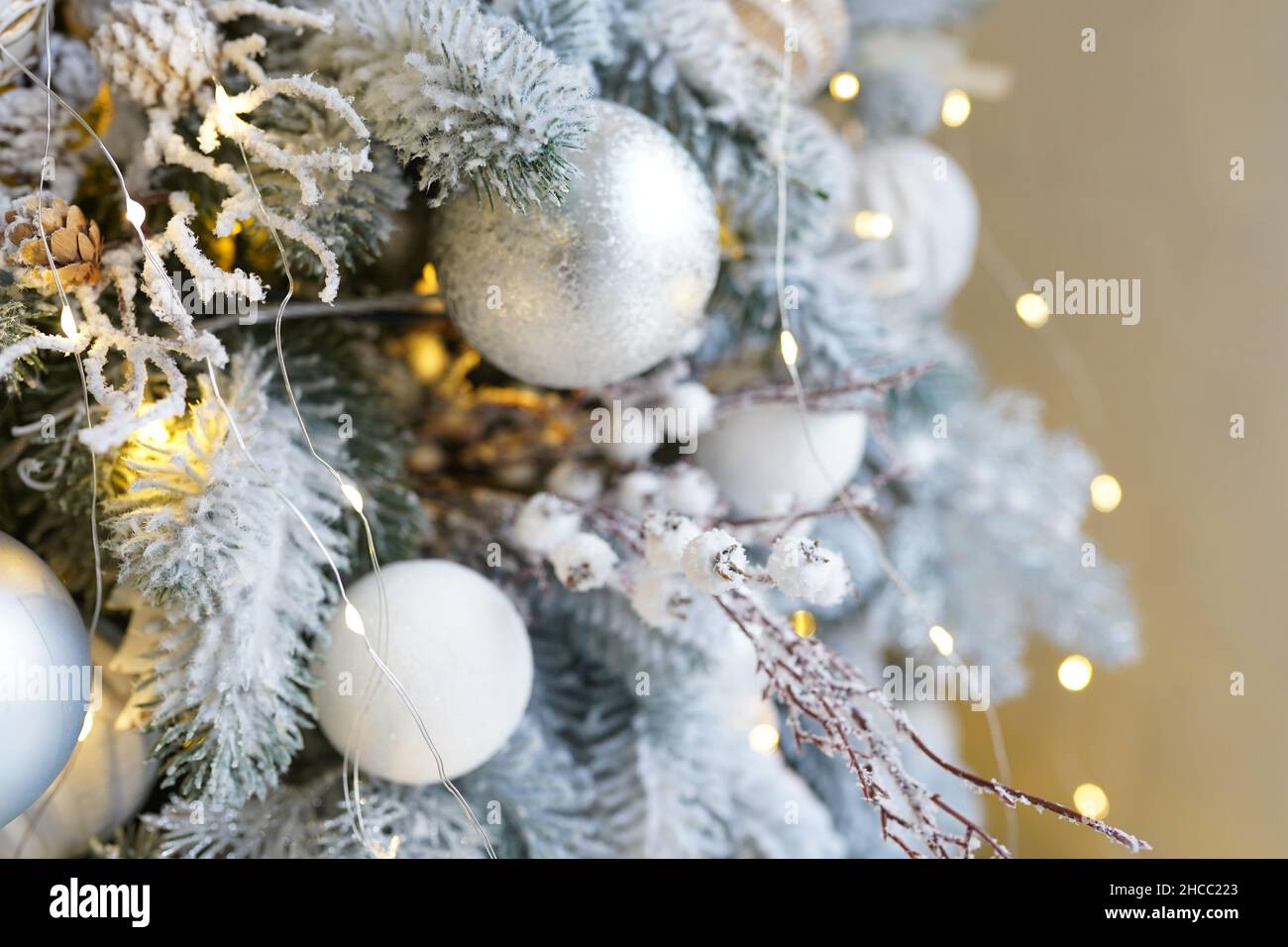 Décorations de Noël sur l'arbre de vacances. Boules blanches et argentées guirlande lampes luminescentes sur les branches sont arrosées de neige.Fêtes traditionnelles s Banque D'Images