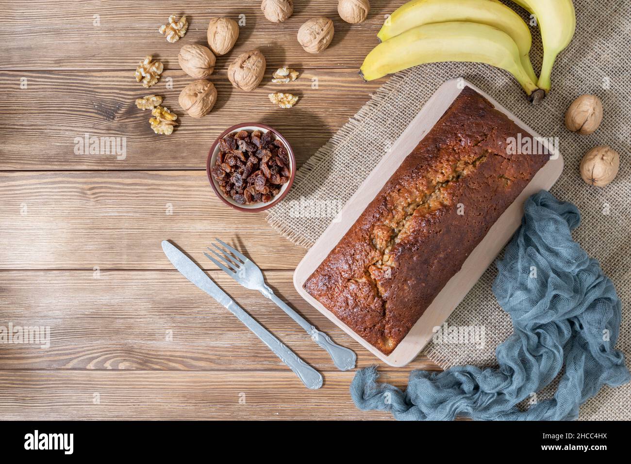 Vue panoramique sur un pain à la banane avec noix, raisins secs et bananes sur un fond rustique en bois Banque D'Images