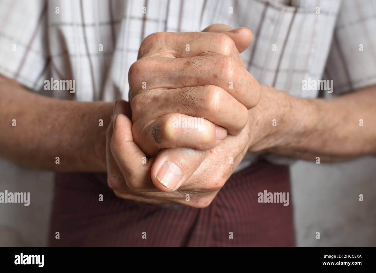 Les mains de l'homme aîné d'Asie du Sud-est ont été jointes.Concept de douleur de main, d'arthrite et de problèmes articulaires. Banque D'Images