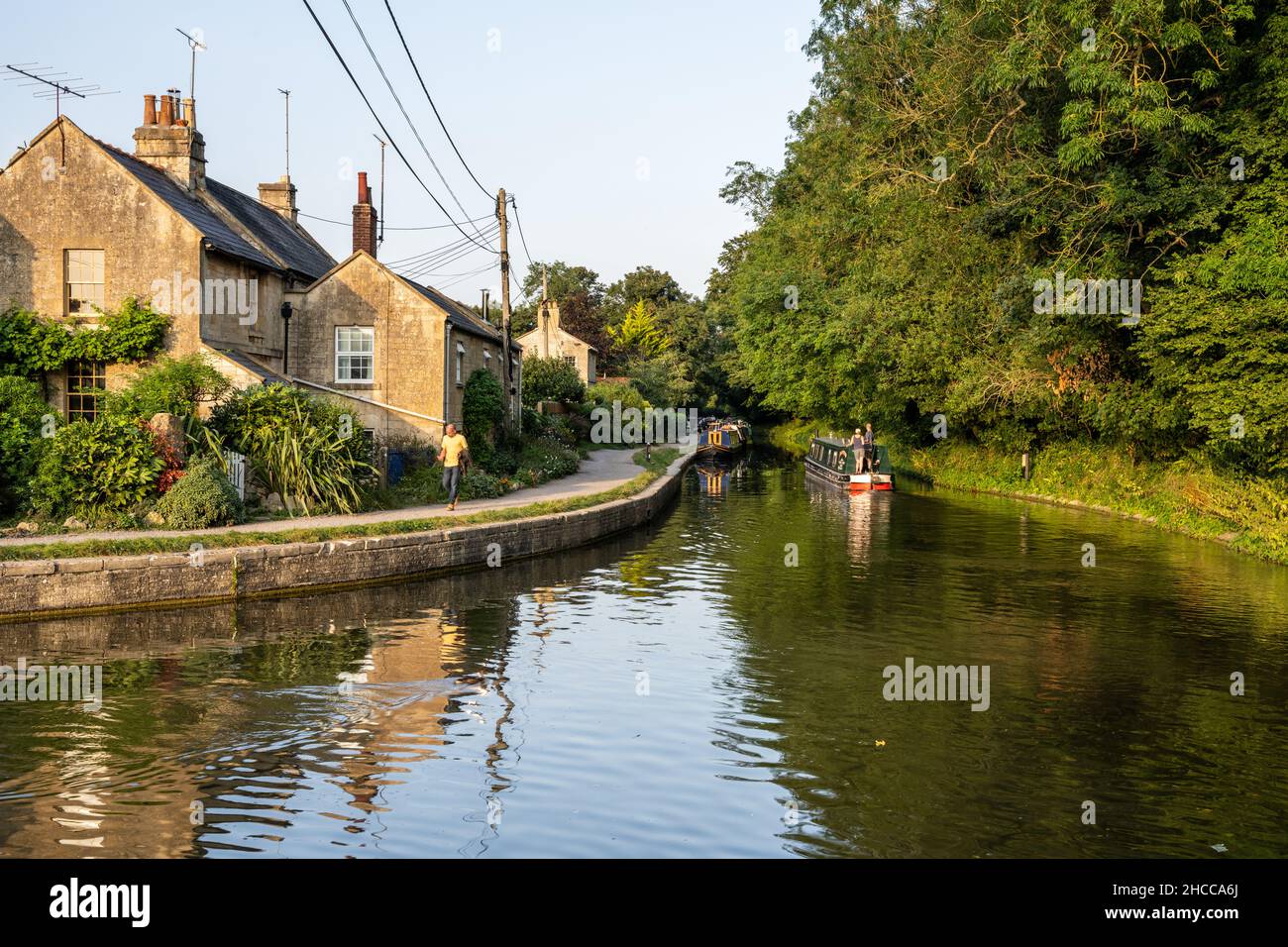 Des bateaux étroits traditionnels passent devant des cottages à Avoncliff sur le canal Kennet et Avon. Banque D'Images