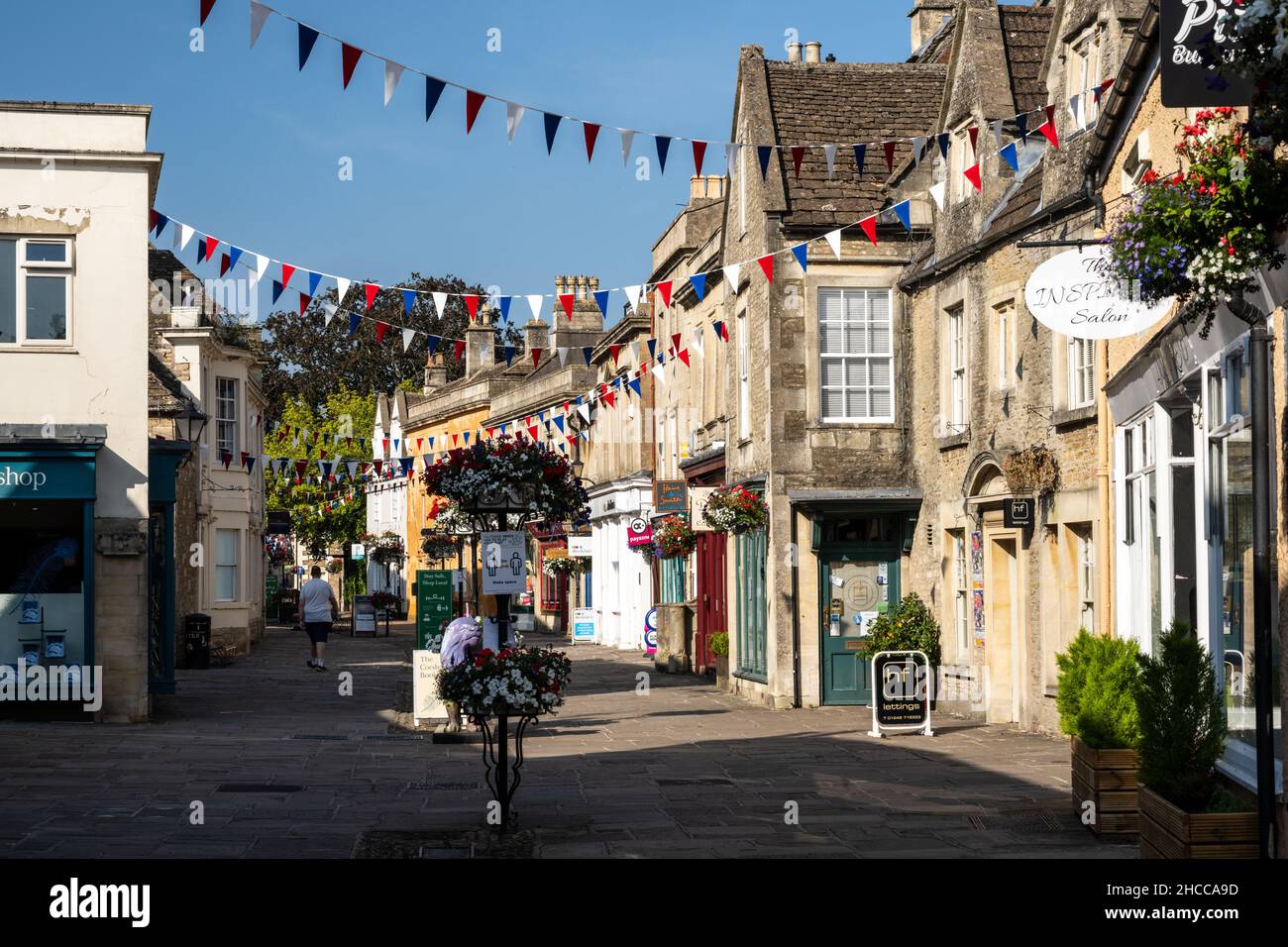 Les boutiques sont décorées de banderoles et de paniers de fleurs sur la traditionnelle High Street de Corsham dans le Wiltshire. Banque D'Images