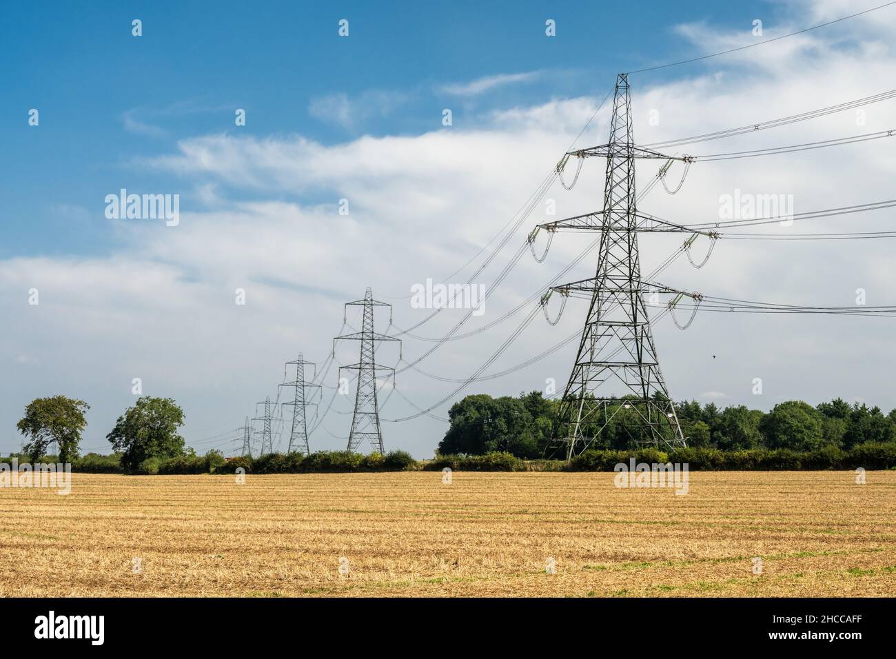 Les lignes électriques du réseau national traversent les terres arables près de Nettleton, dans les Cotswolds Hills d'Angleterre. Banque D'Images