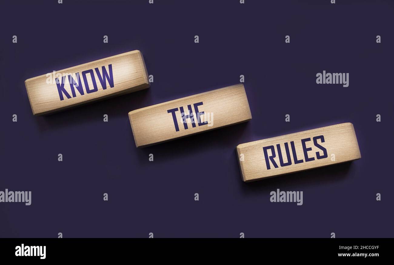 Connaître les mots de règles sur des blocs de bois isolés sur fond bleu. Concept de régulation de processus d'affaires. Banque D'Images