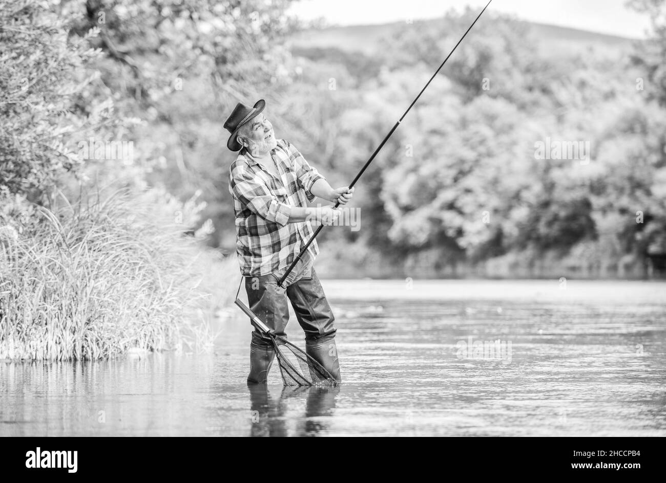 La pêche est amusante. Homme adulte pêche à la mouche. Homme pêche. Week-end d'été.Pêche au gros gibier. Pêcheur barbu à la retraite.Appât de truite. Pêcheur avec Banque D'Images