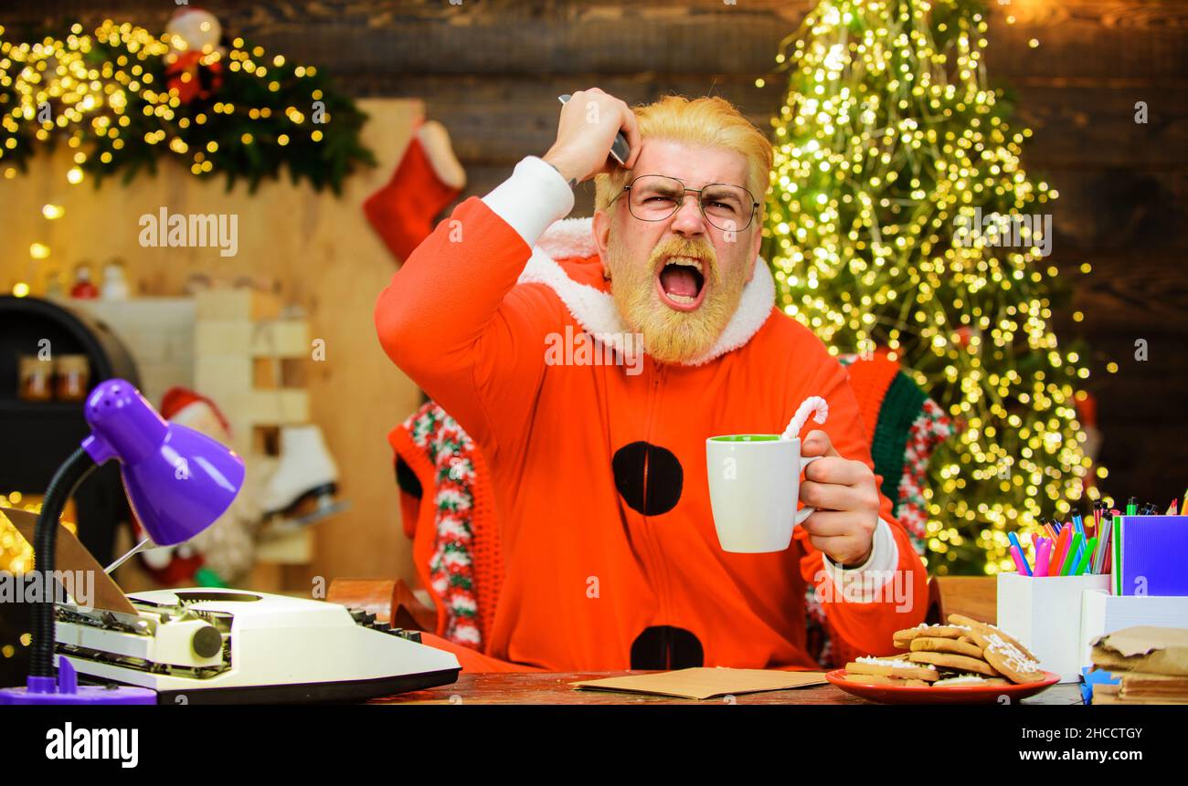 Le Père Noël en colère boit du café et regarde le film de Noël.Concept cinéma.Bonne Année. Banque D'Images