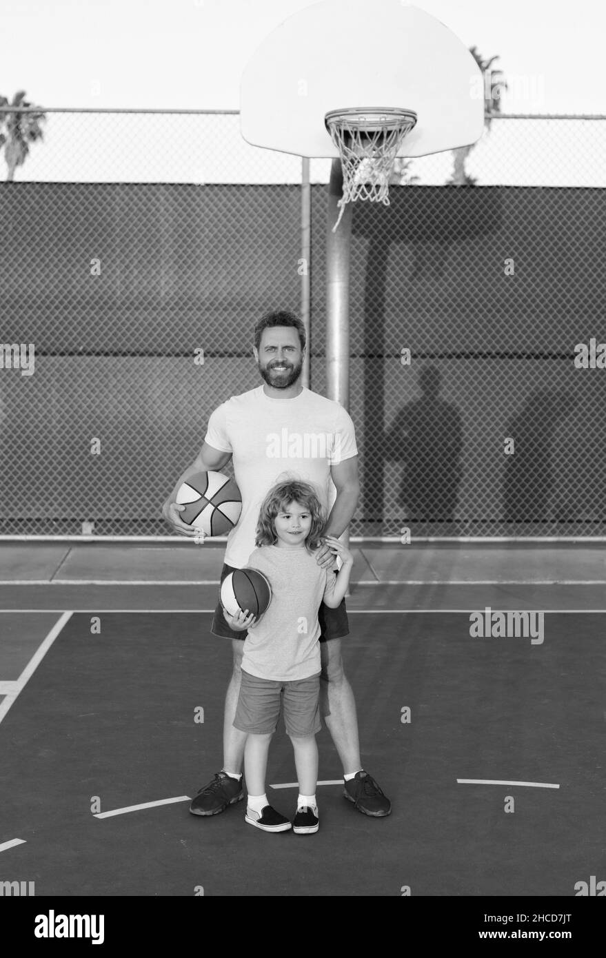 joyeux papa et fils enfant jouer au basket-ball avec le ballon sur le terrain de jeu, la paternité Banque D'Images