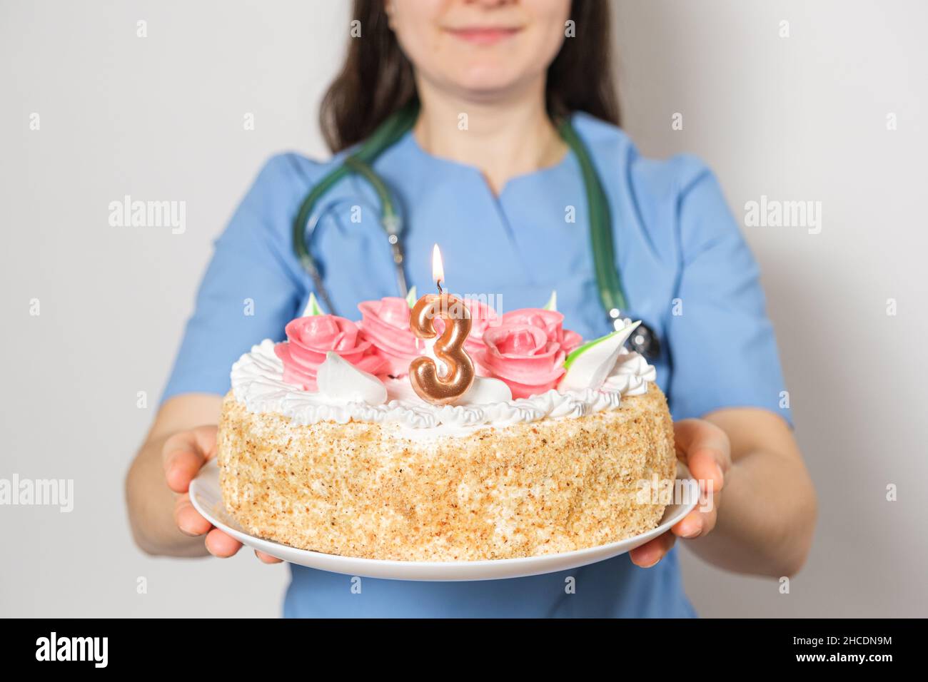 Le Medecin Ou L Infirmiere Tient Un Gateau D Anniversaire Avec Le Numero Trois Pour L Anniversaire De L Ouverture De La Clinique Photo Stock Alamy