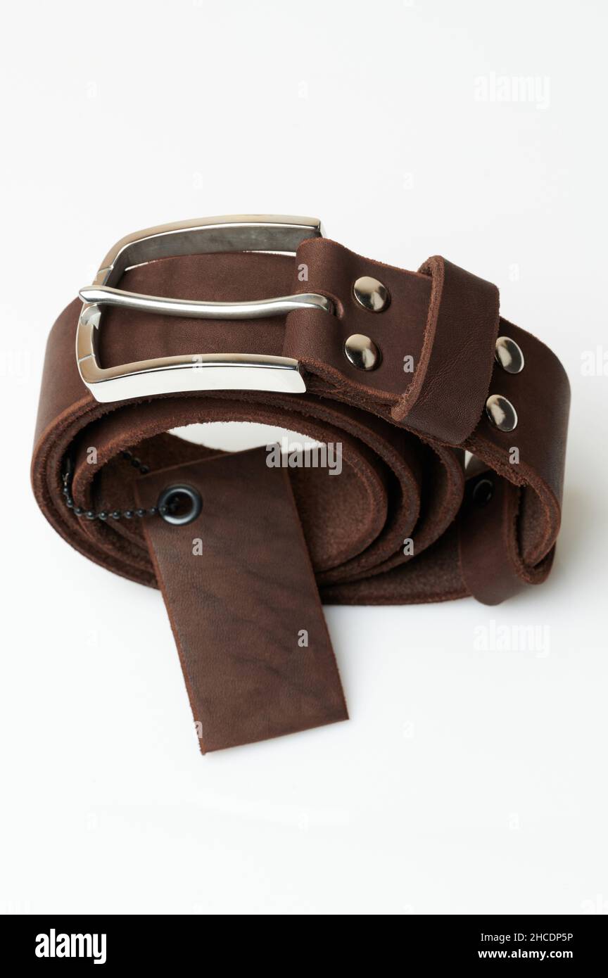 Nouvelle ceinture en cuir classique avec étiquette isolée sur le fond du studio Banque D'Images