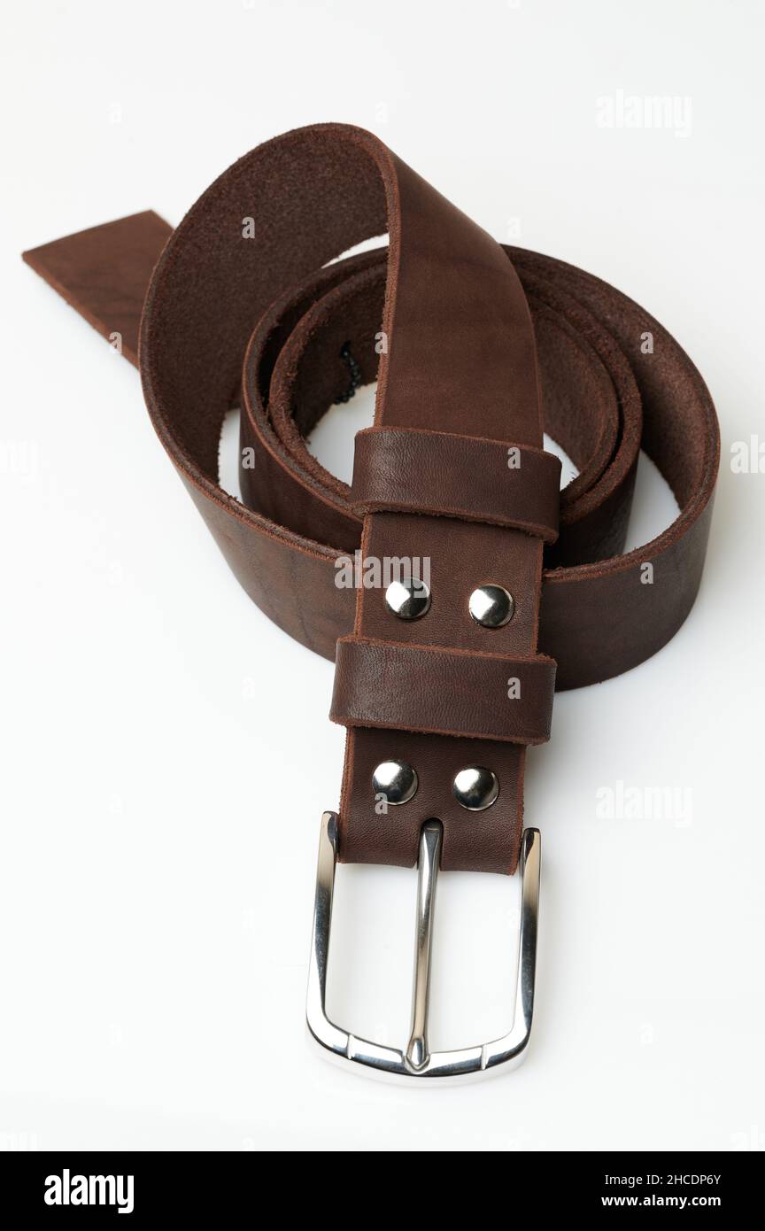 Élégante ceinture en cuir brun roulée isolée sur fond blanc de studio Banque D'Images