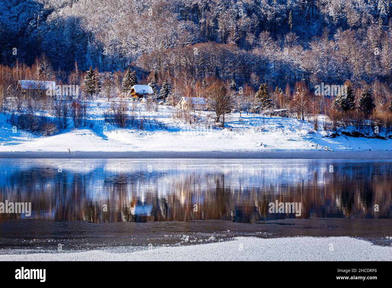 Petits chalets forestiers sur la rive du lac Poiana Marului pendant une journée d'hiver parfaite.Photo prise le 17th janvier 2021 dans la réserve de Poiana Marului, Banque D'Images