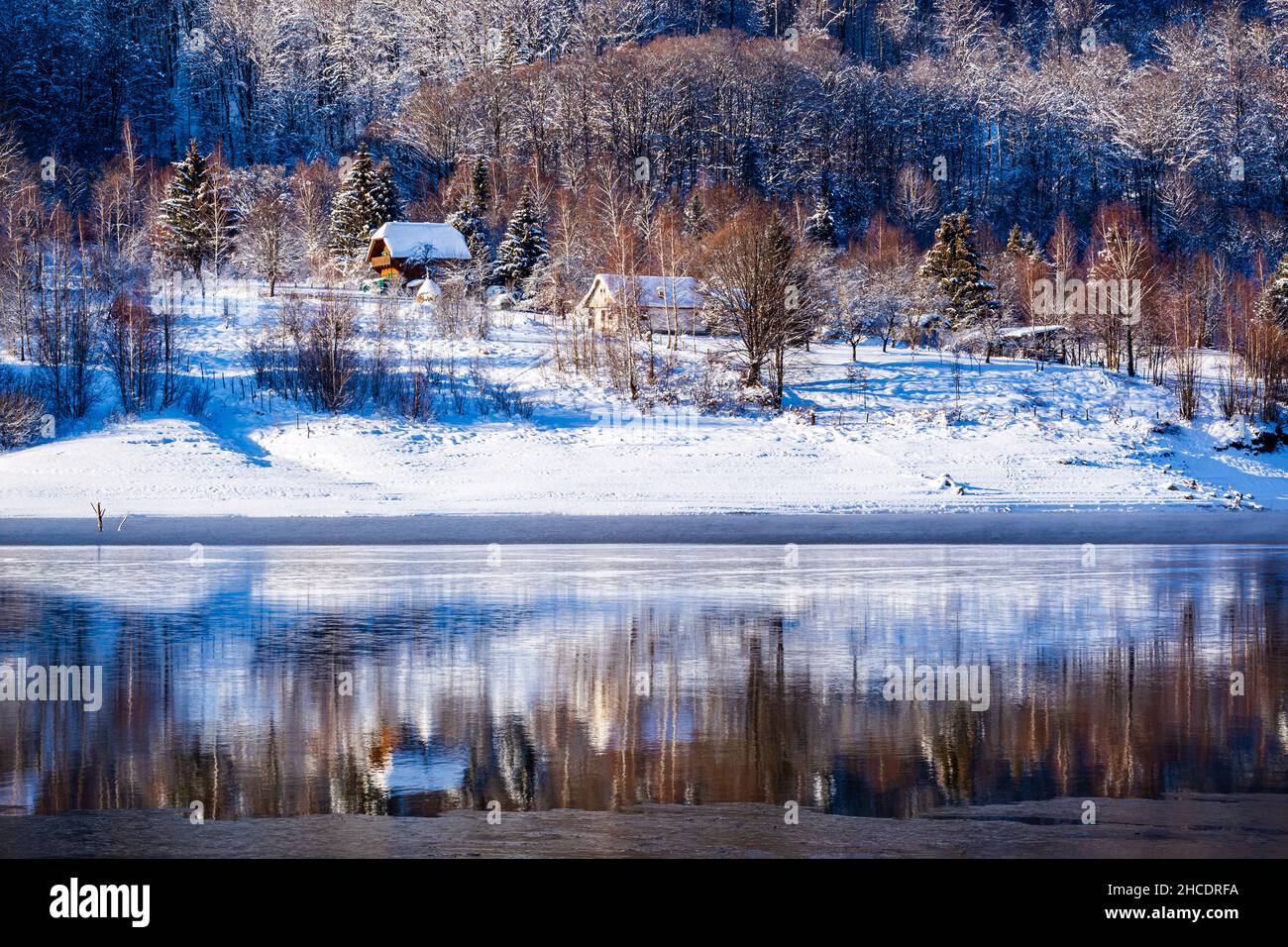 Petits chalets forestiers sur la rive du lac Poiana Marului pendant une journée d'hiver parfaite.Photo prise le 17th janvier 2021 dans la réserve de Poiana Marului, Banque D'Images