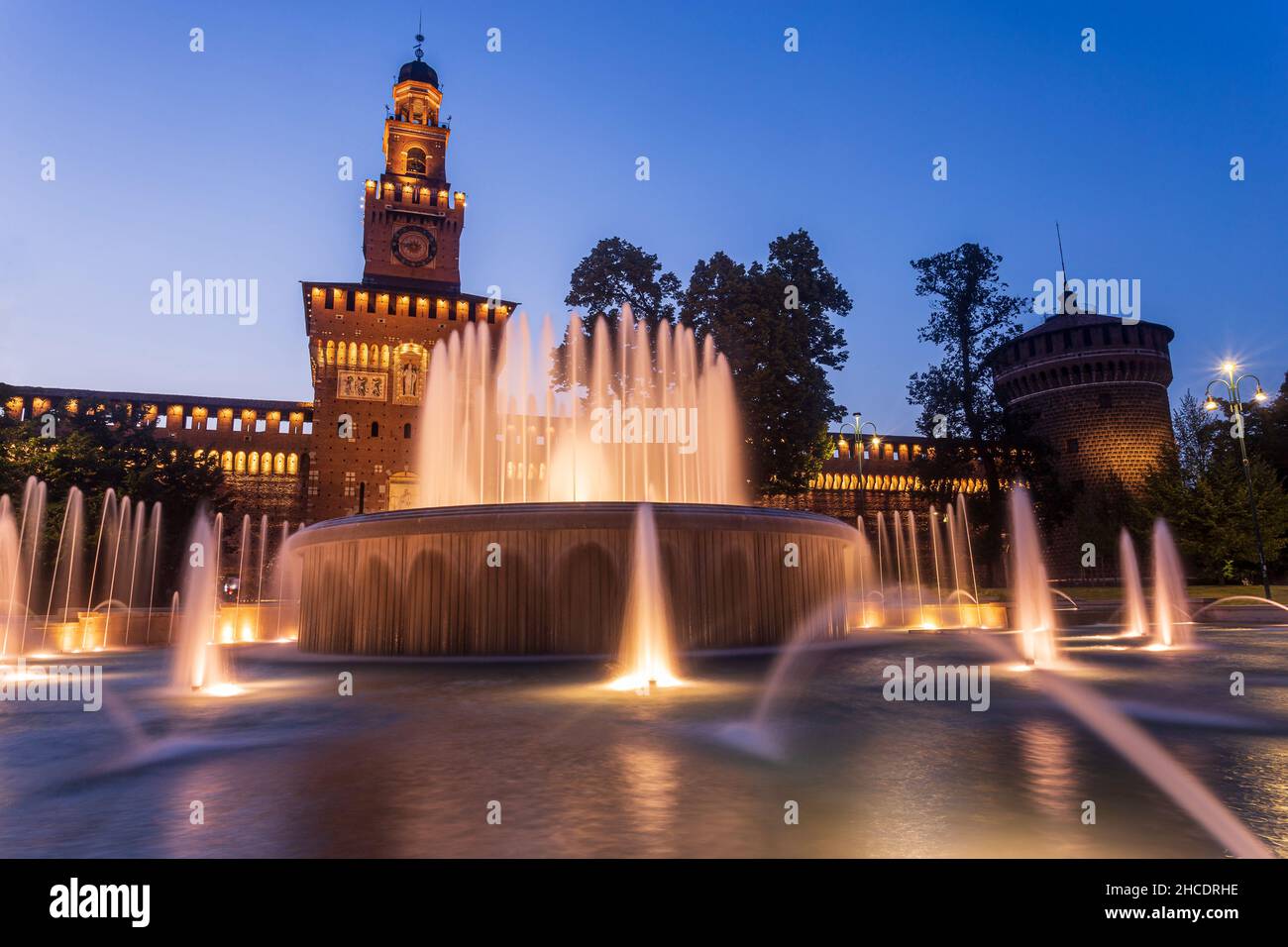 Fontaines d'eau en face du château de Sforza (Castello Sforzesco) vu pendant l'heure bleue du coucher du soleil.Photo prise le 19th août 2021 à Mila Banque D'Images