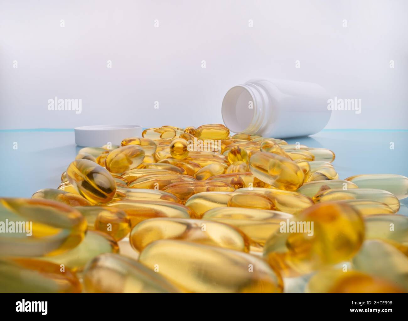 Capsules de graisse Omega 3 pour un coeur et des vaisseaux sanguins sains.Gros plan perspective, arrière-plan bleu. Banque D'Images