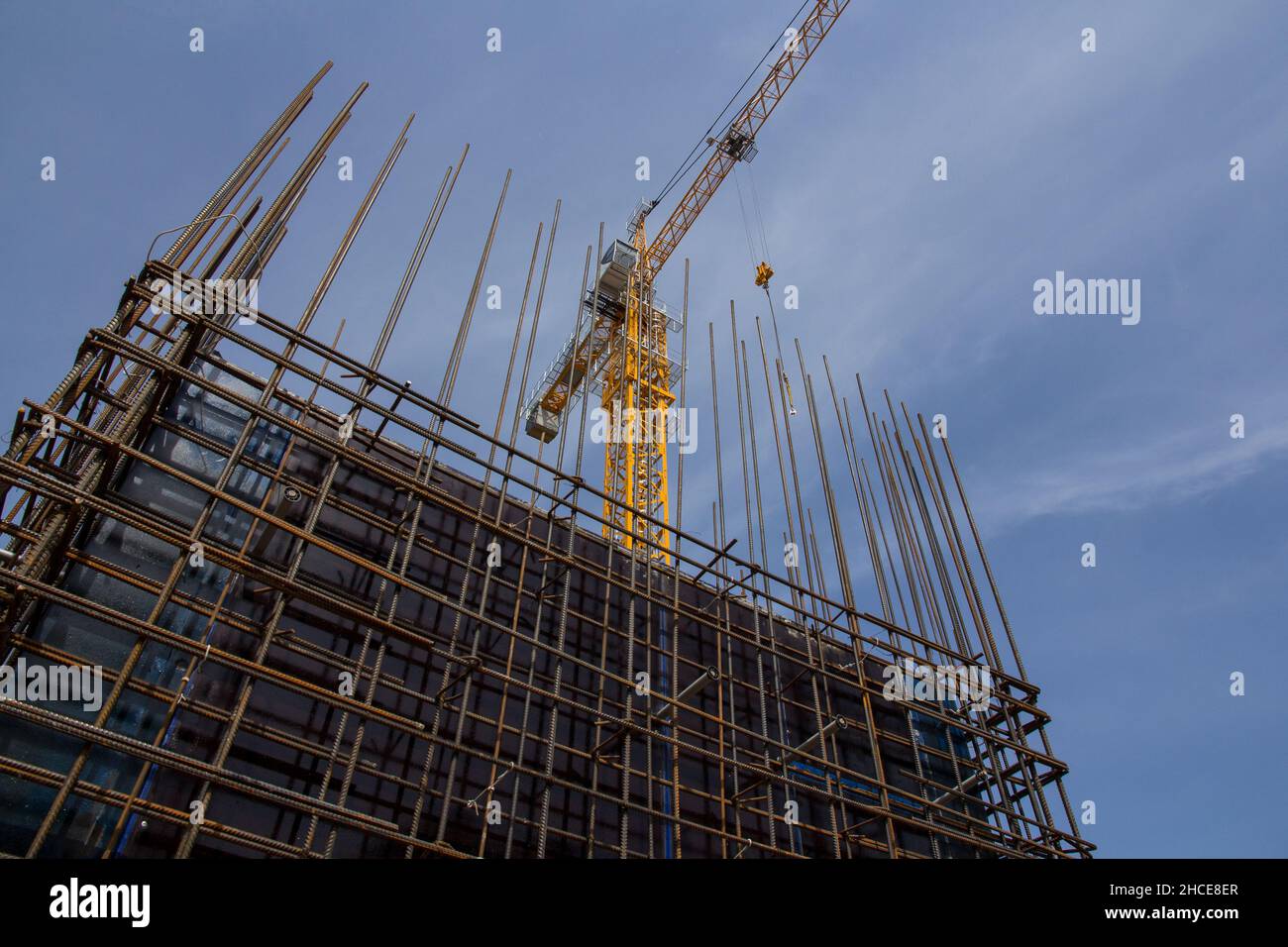 Structure en béton armé et grue à tour contre le ciel bleu.Construction de fondations.Structure en béton du chantier.Processus de construction Banque D'Images