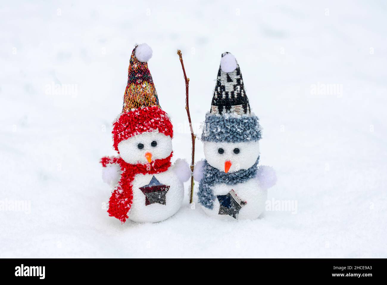 Joyeux noël et bonne année carte de voeux avec espace copie deux petits bonshommes de neige heureux en rouge, bleu casquette et écharpe debout dans le fond de neige d'hiver Banque D'Images