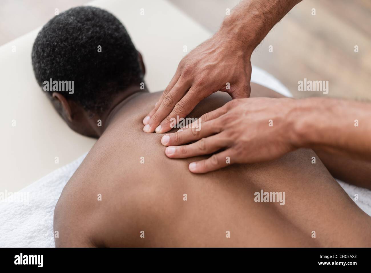 africain américain homme recevant un massage de dos pendant le traitement dans le centre de réadaptation Banque D'Images
