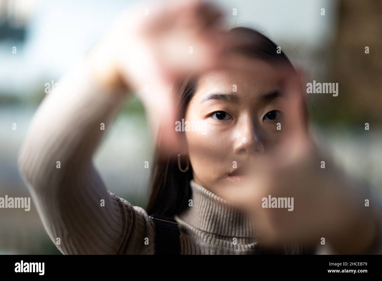 Gros plan d'une jeune fille asiatique adolescente cadrage avec ses mains Banque D'Images