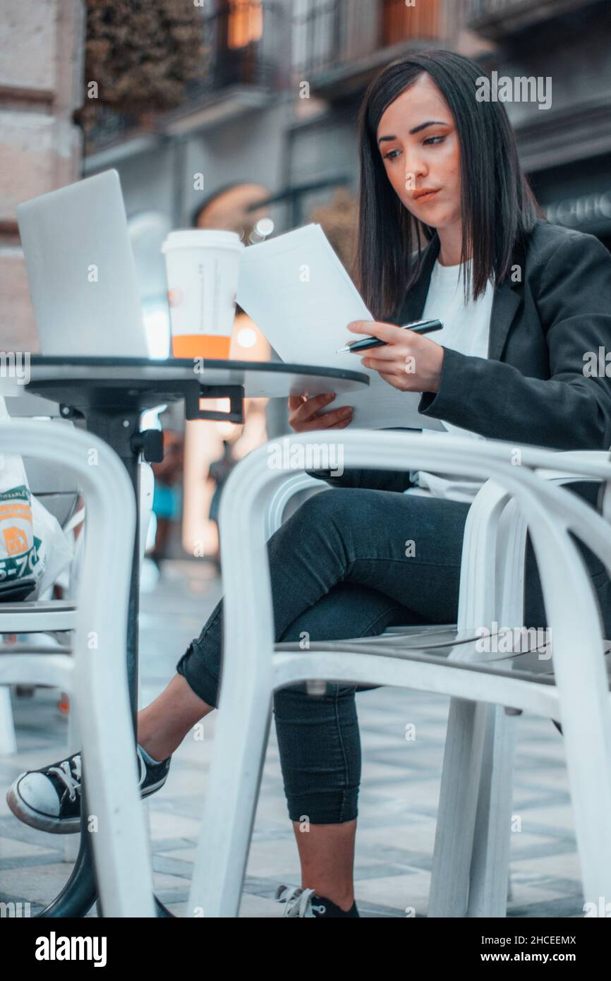 Femme d'affaires en ligne faisant quelques annotations de rapports avec son ordinateur portable Banque D'Images