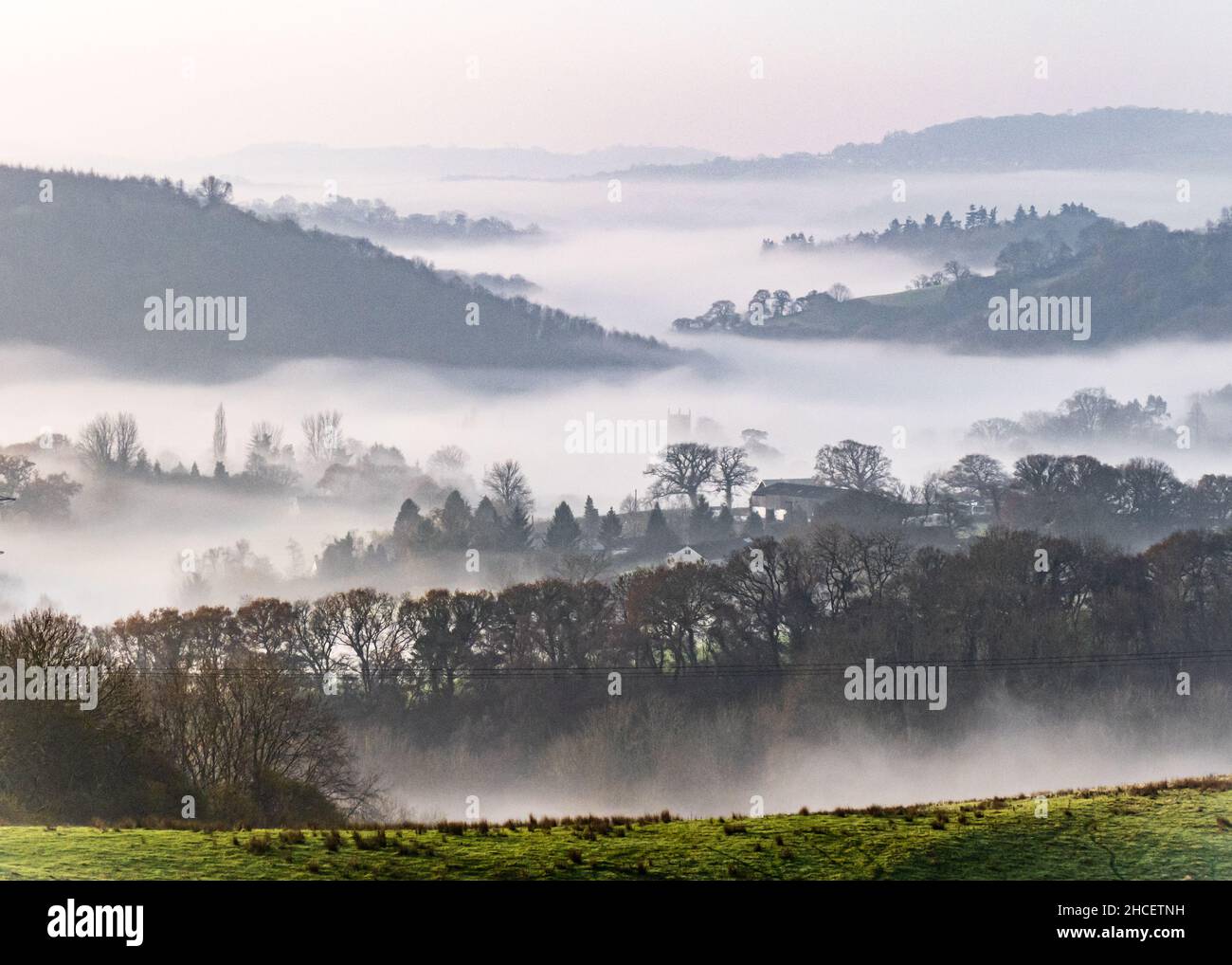 Royaume-Uni, Angleterre, Devonshire, Teign Valley.Brume matinale au-dessus de la tour de l'église de Doddiscombsleigh dans la vallée ci-dessous. Banque D'Images